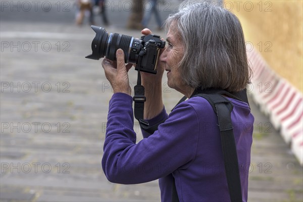 Tourist taking photos in the harbour of Genoa, Italy, Europe