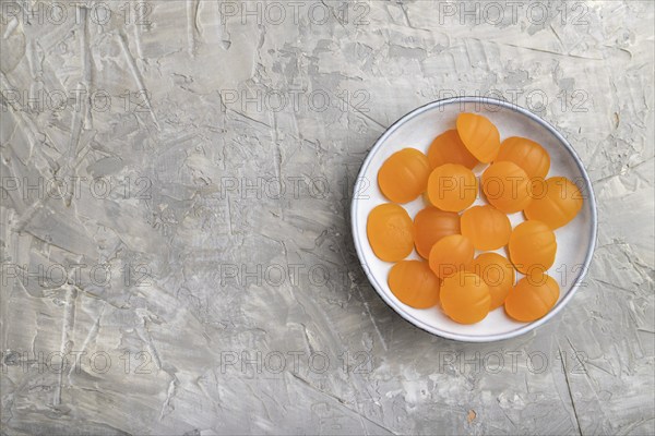 Jelly pumpkin candies on gray concrete background. copy space, top view, flat lay. autumn concept