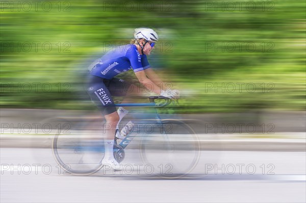 Cyclist in blue jersey riding fast on a road, movement and speed blur the image, race, Stuttgart,