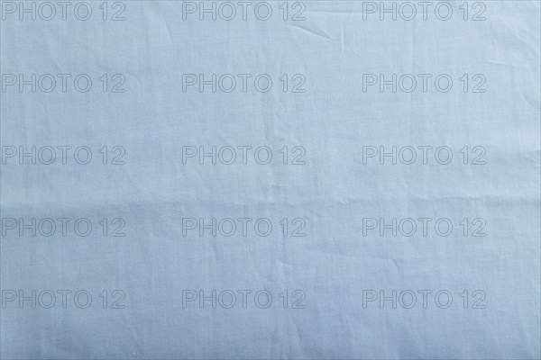 Fragment of smooth cotton blue tissue. Top view, flat lay, natural textile background and texture