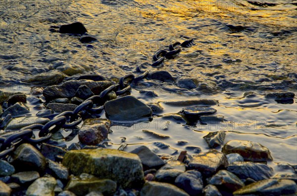 Metal Chain in the Water with Stones in Switzerland