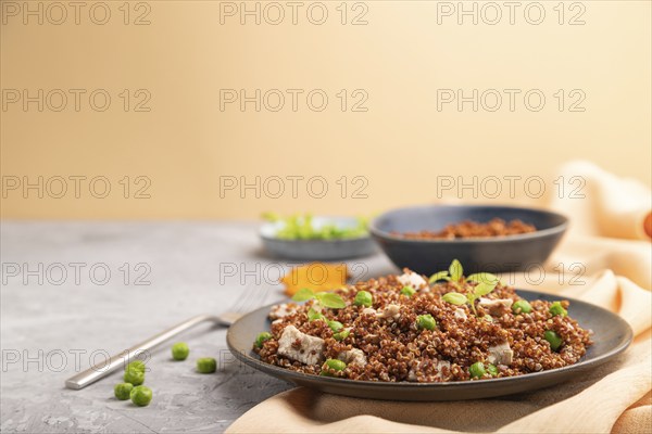 Quinoa porridge with green pea and chicken on ceramic plate on a gray concrete background and
