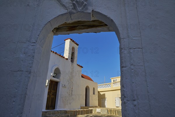 View through an arch of a traditional building against a clear blue sky, Agios Ioannis church,