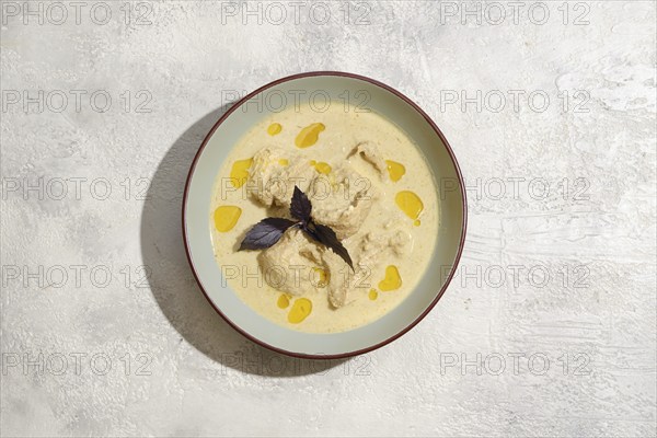 Overhead view of plate with pieces of chicken stewed in walnut sauce