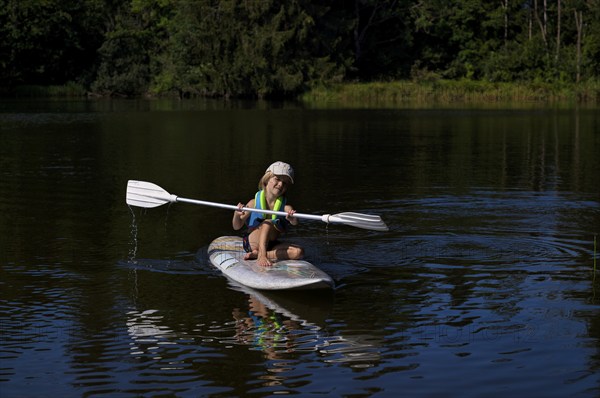 Little boy, 4 years old, paddling on surfboard, surfboard, lake, Schwaltenweiher, honey village