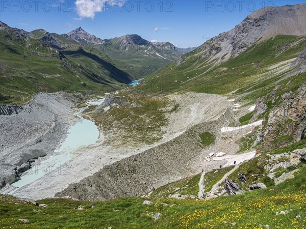 Hiking trail up to mountain hut Cabane de Moiry, glacial moraine, lake Lac de Moiry in the back,