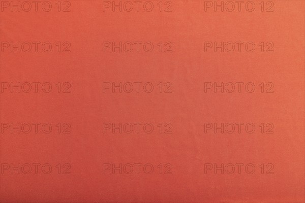 Fragment of smooth red silk tissue. Top view, flat lay, natural textile background and texture