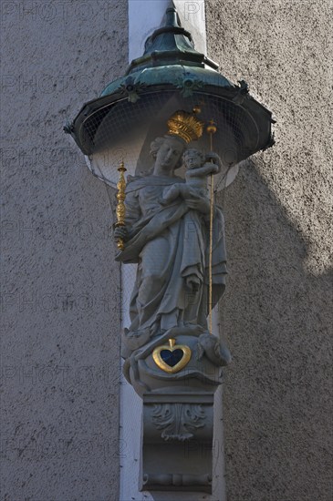 Sculpture of St Mary with the infant Jesus under a canopy on the corner of a house, Regensburg,