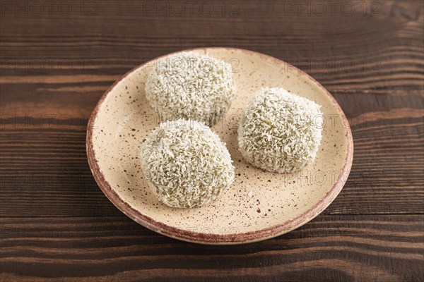 Japanese rice sweet buns mochi filled with pandan and coconut jam on brown wooden background. side