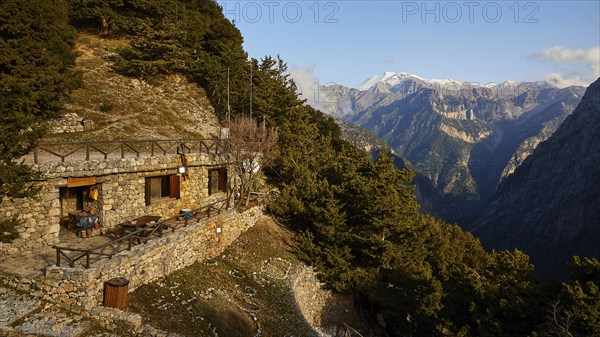 A lonely stone house on a mountain with breathtaking views of the forested mountains, entrance to
