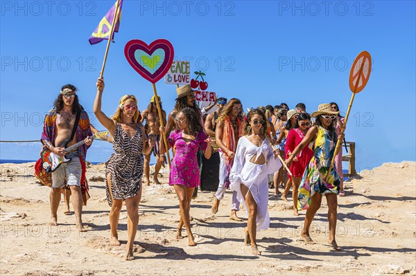 Colourfully dressed youths with musical instruments and banners form a love parade and promote the