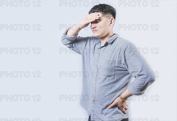 Tired man holding his head isolated. Worried young man holding his forehead isolated