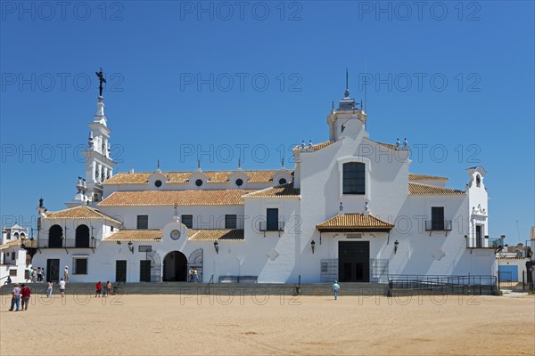 Eine weiße Kirche mit typischer spanischer Architektur vor einem klaren blauen Himmel und