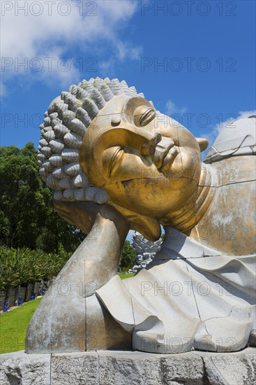 Close-up of a reclining Buddha statue radiating meditative calm against a clear blue sky, Bacalhôa,