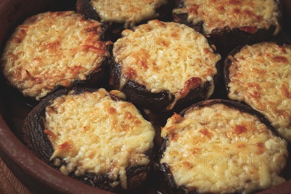 Portabello mushrooms stuffed with suluguni cheese in a clay pan, ketsi, Georgian cuisine, hot