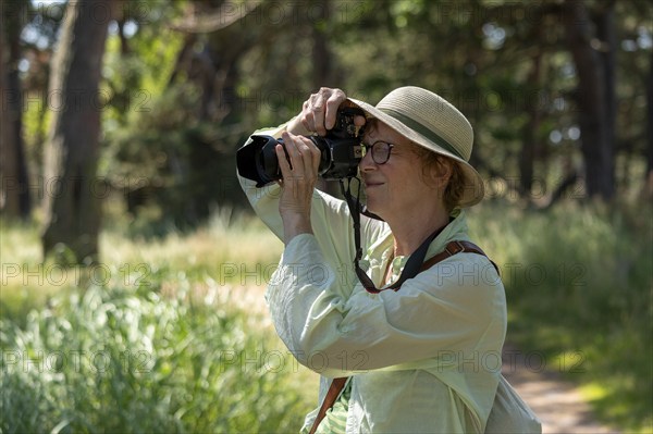 Woman taking photos, trees, circular hiking trail, Darßer Ort, Born a. Darß, Mecklenburg-Western