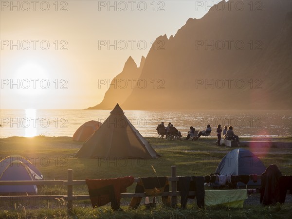 Beach Ersfjordstranden, fjord Ersfjord, people sitting in small groups at the beach, public