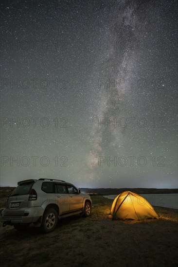 Off-road vehicle and tent, night shot, Milky Way at Lake Issyk Kul, Kyrgyzstan, Asia