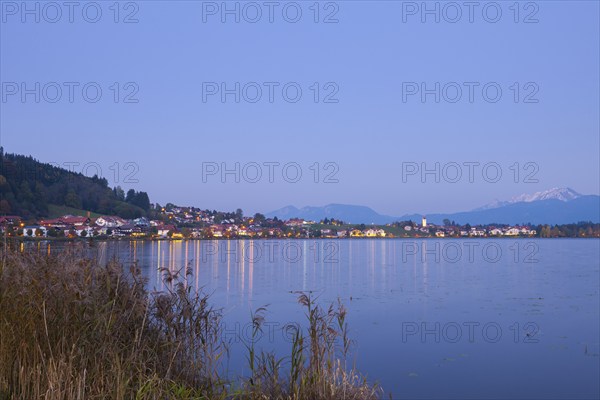 Village on the lakeshore at dusk, mountains in the background, quiet atmosphere, Hopfen am See,