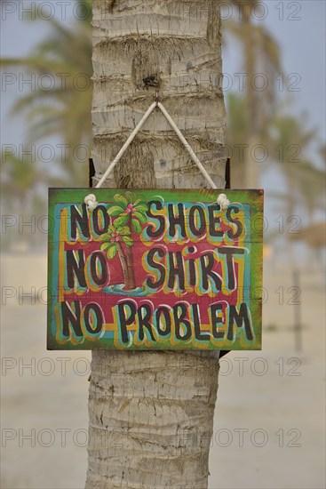 Sign "No shoes, no shirt, no problem" on the beach of Salalah Rotana Resort, Salalah, Dhofar