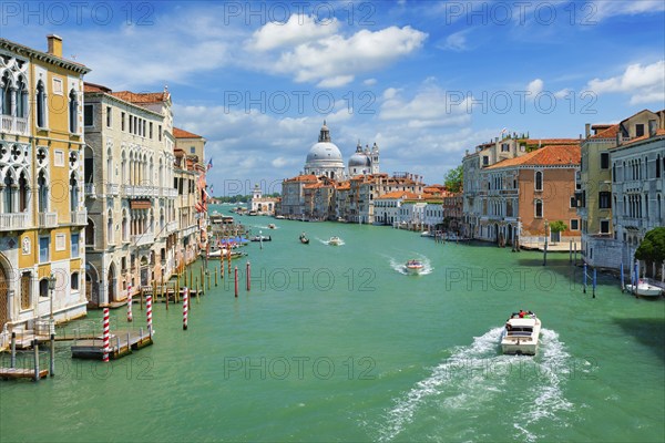 View of Venice Grand Canal with boats and Santa Maria della Salute church in the day from Ponte
