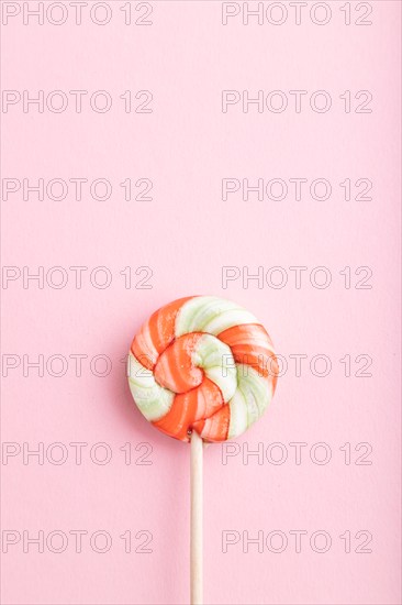 Single lollipop candy on pink pastel background. copy space, top view, flat lay