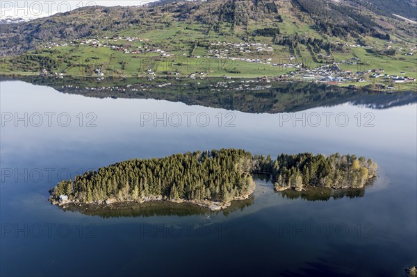 Island with small holiday cottage, lake Hafslovatnet east of town Sogndal, reflections in the lake,