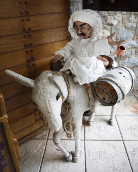 Cloth donkey carrying a male doll and wine barrels, mountain village Langadia, Arcadia,