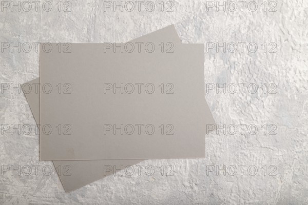 Gray paper business card, mockup on gray concrete background. Blank, flat lay, top view, still