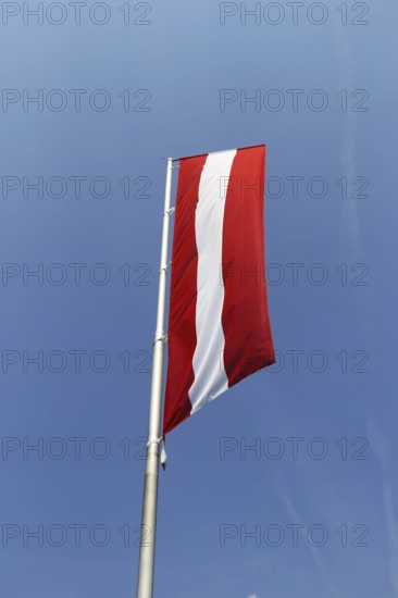 Österreichische Flagge vor blauem Himmel (Austrian flag in front of a blue sky)