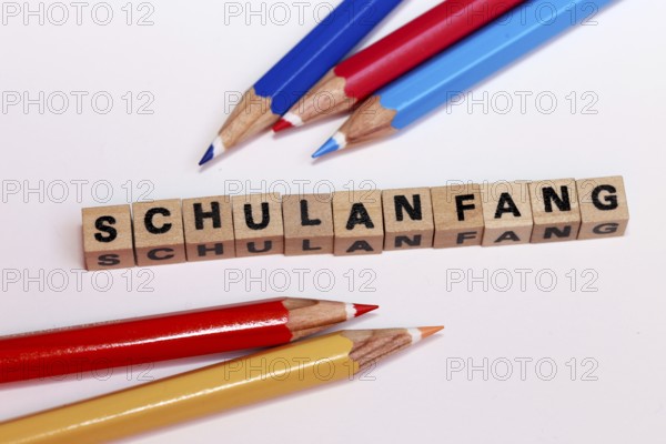 Symbolic image for the start of the new school year with letter cubes and pens