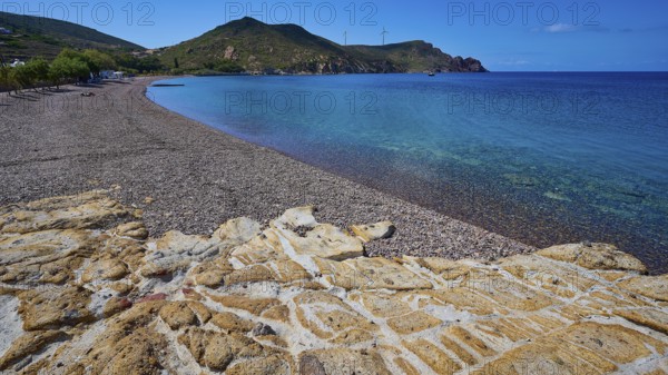 Beach with pebbles, mountains and clear blue water under a blue sky, Lambi beach, pebble beach,