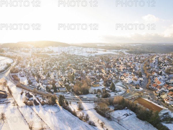 Snow-covered village in a vast landscape with low sun, Calw- Stammheim, Black Forest, Germany,