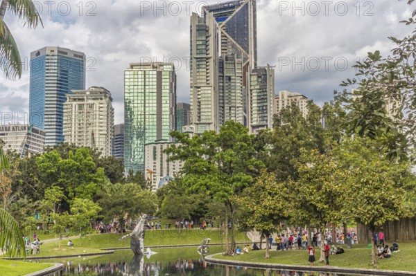 The city park with a small lake with buildings on background