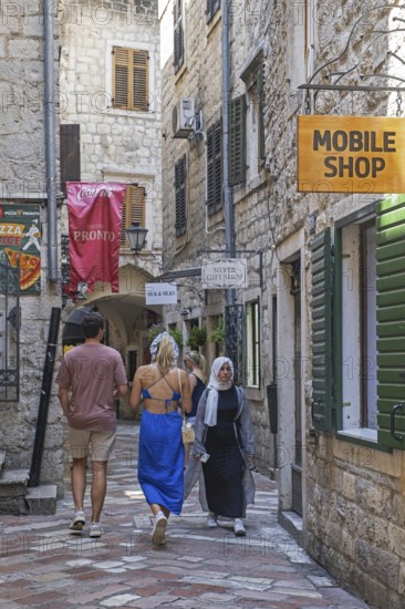Western tourists and Muslim woman, muslima shopping in narrow alley in the Venetian Old Town centre