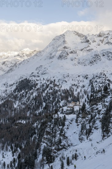 Mountain hut Zufallhütte in snowy mountain landscape, with mountain peak Vorderer Rotspitz,