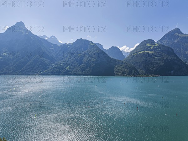 Lake Uri, part of Lake Lucerne near Flüelen, windsurfers in front of the mountains of the Alps.
