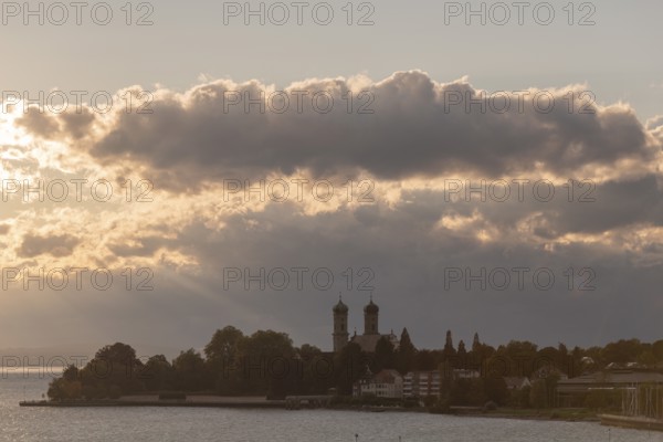 Baroque castle church, double tower, onion dome, evening light, sunbeams, Friedrichshafen on Lake