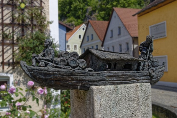 Finely crafted bronze sculpture of an old travelling ship on a pedestal next to flowers, Kallmünz,