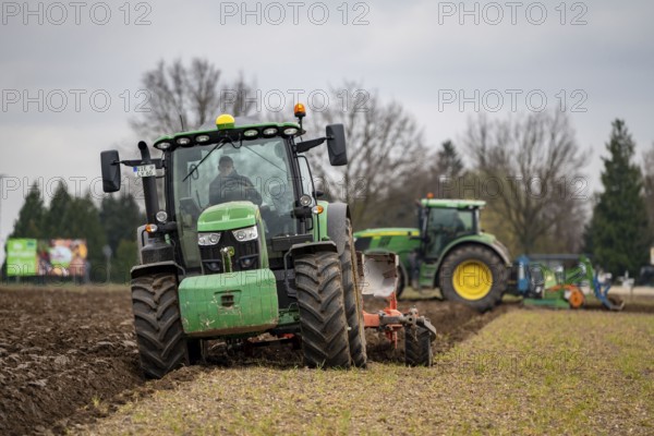 Tractor with a power harrow prepares the soil of a field for planting, Agriculture, Spring