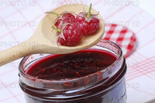 Raspberries (Rubus idaeus) on raspberry jam, raspberry jam, wooden spoon