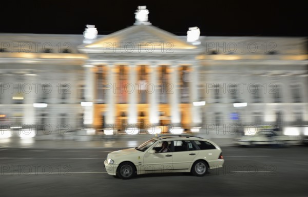 Taxi at night in front of the Teatro Dona Maria II National Theatre in Rossio Square, or Praça Dom