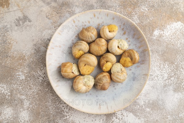 Grape (Burgundy) snails with butter and cheese on brown concrete background. Top view, flat lay