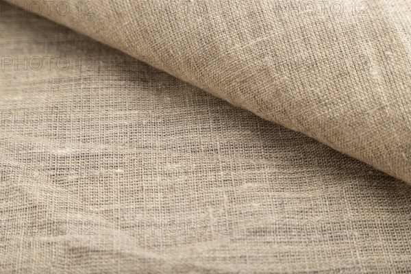 Fragment of rough linen tissue. Side view, natural textile background and texture