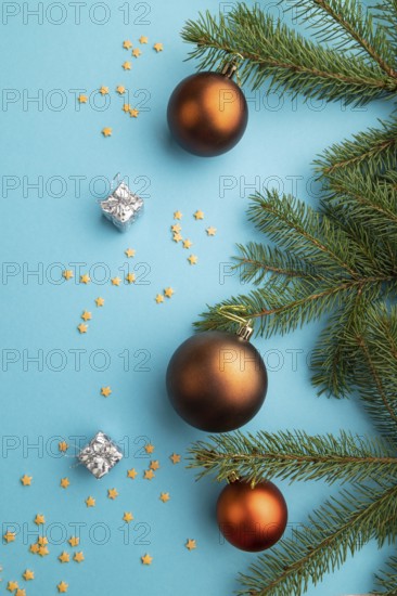 Christmas or New Year composition. Decorations, bronze balls, fir and spruce branches, on a blue