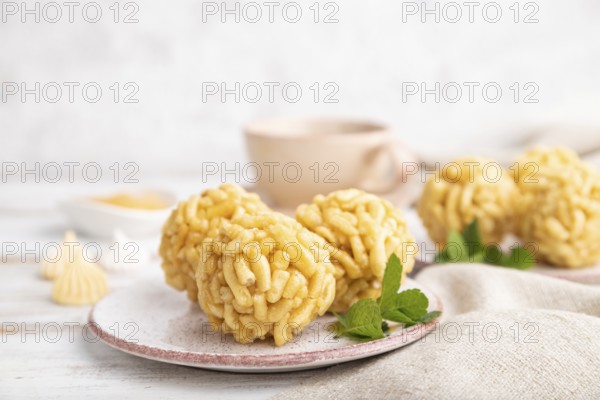 Traditional Tatar candy chak-chak made of dough and honey with cup of coffee on a white wooden