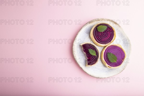 Sweet tartlets with jelly and milk cream on a pastel pink background. top view, flat lay, copy