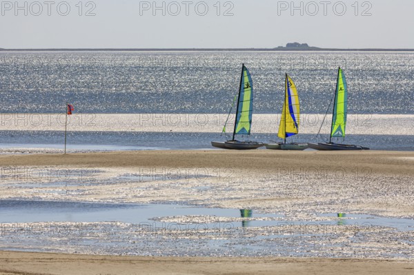 Small sailing boats on the beach, catamaran, behind Hallig, backlight, sunny, summer, North Sea