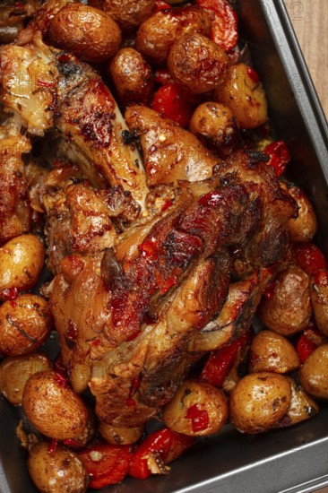 Pork knuckle, baked with vegetables, new potatoes, on a baking sheet, homemade, no people