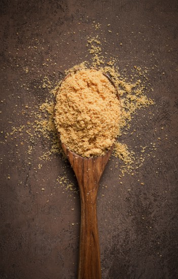 Wooden spoon with hazelnut flour, top view, no people, on a table